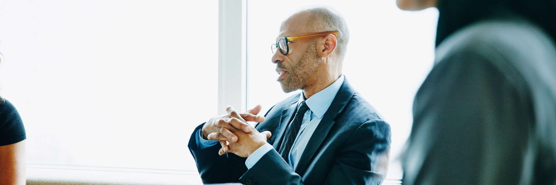 Mature businessman discussing project with colleague during meeting in office